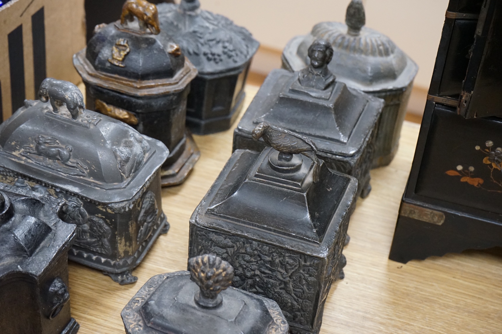 A collection of ten early 19th century lead tobacco boxes, one in the form of a monument with lion knop, largest 14cm wide
